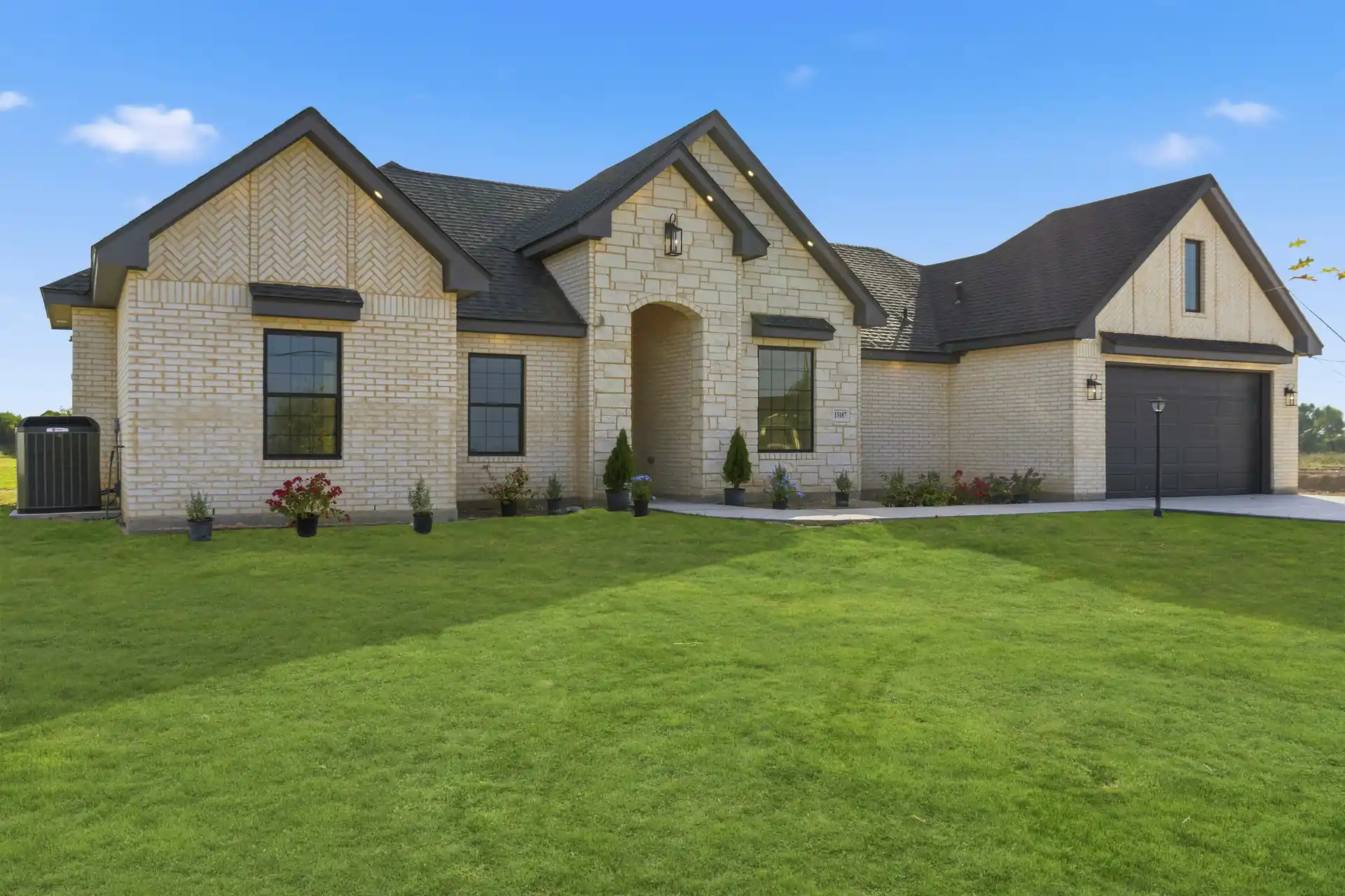 Stone and brick custom home with a landscaped yard, built by Go To Guys RGV in Lyford, TX